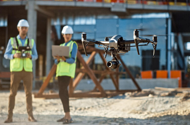 Safety engineering inspector pilots drone around commercial building construction