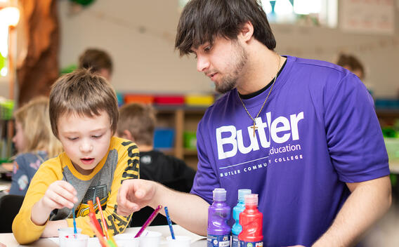Student helping child in classroom
